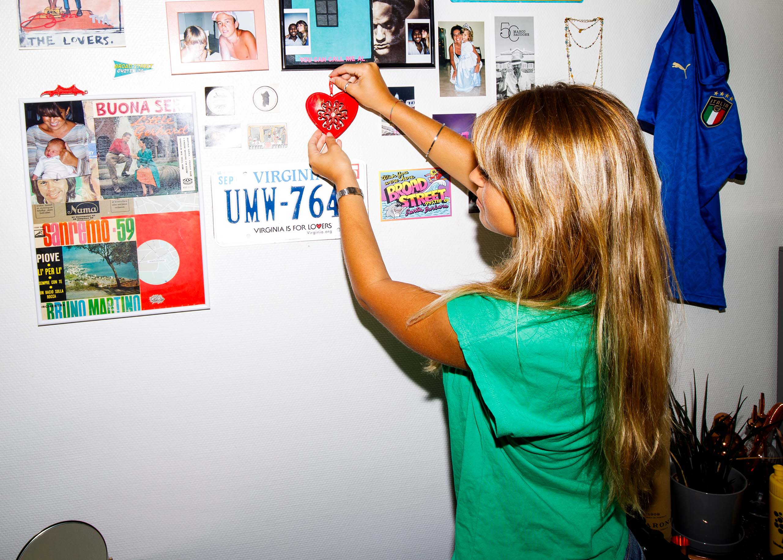 En student i sin studentlägenhet, fäster ett hjärta på väggen.